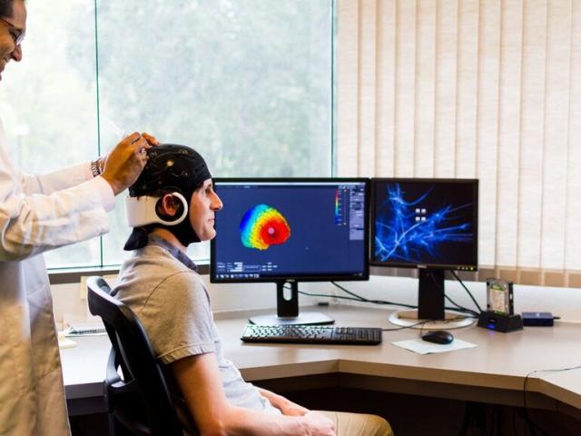Researcher adjusting EEG cap