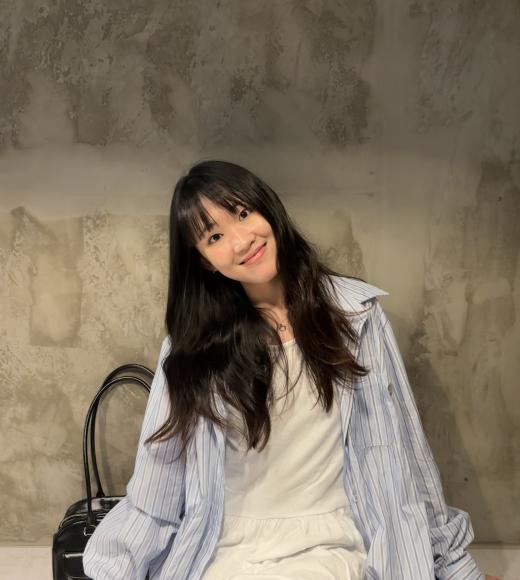 Person sitting on a bench and posing for a picture.